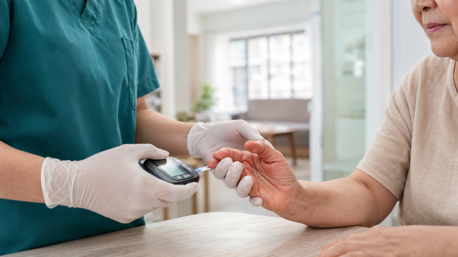 Gloved home nurse performing a fingertip blood-glucose check with a handheld glucometer for an elderly patient at home in Singapore